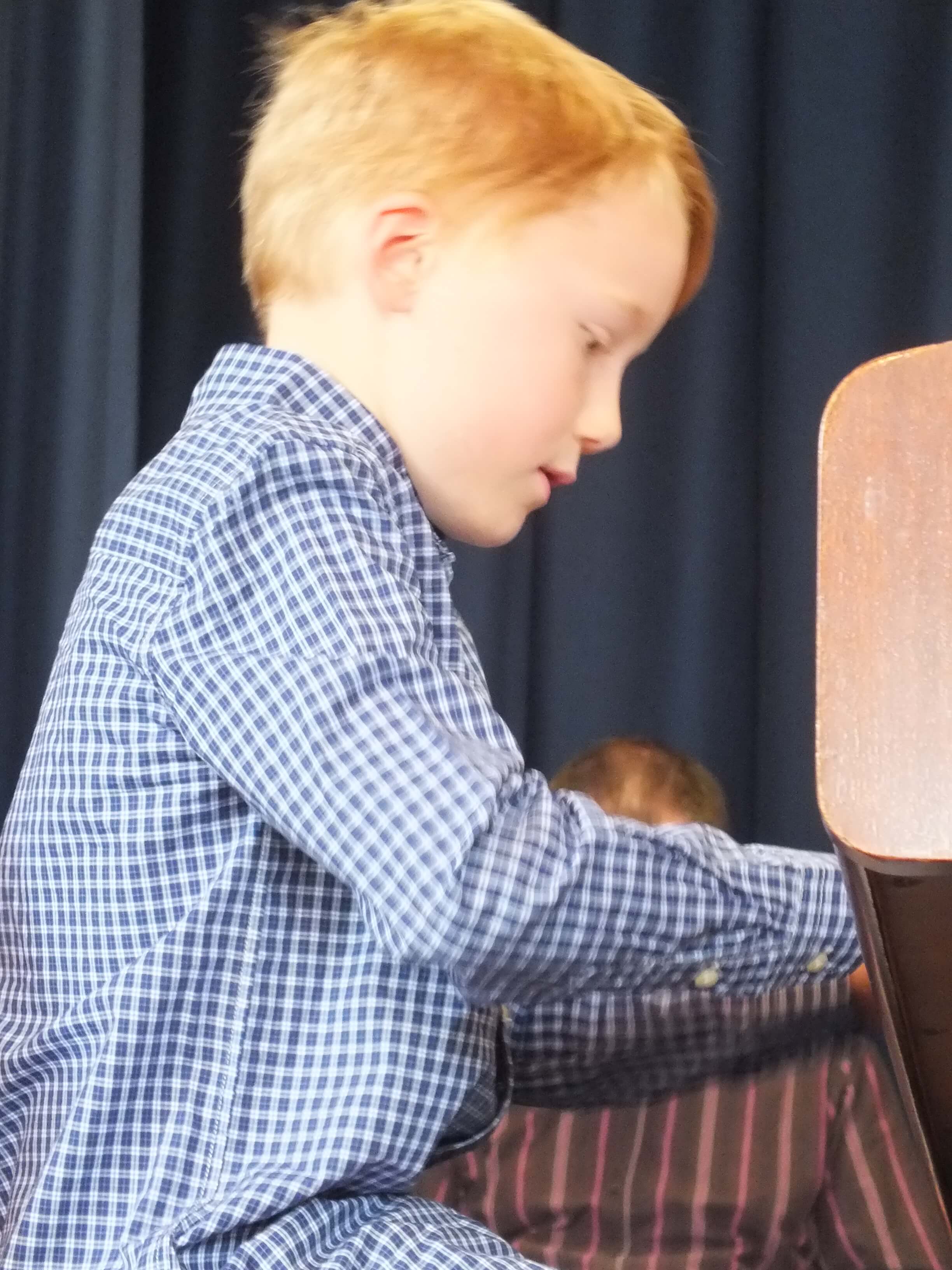 Young Boy Playing Piano at Concert