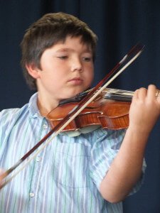 Young Boy Playing Violin at Concert